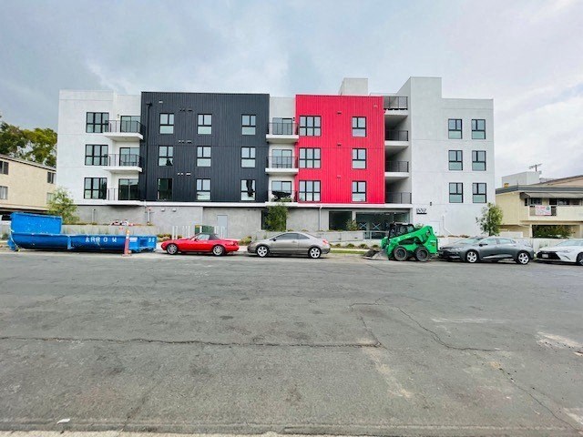 a group of cars parked in front of an apartment building