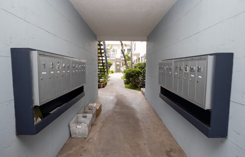 A long hallway with a row of mailboxes on the wall.