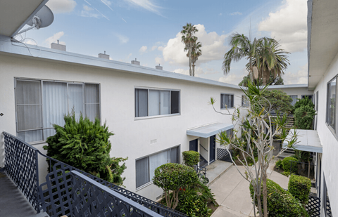 A white building with a balcony and a black railing.