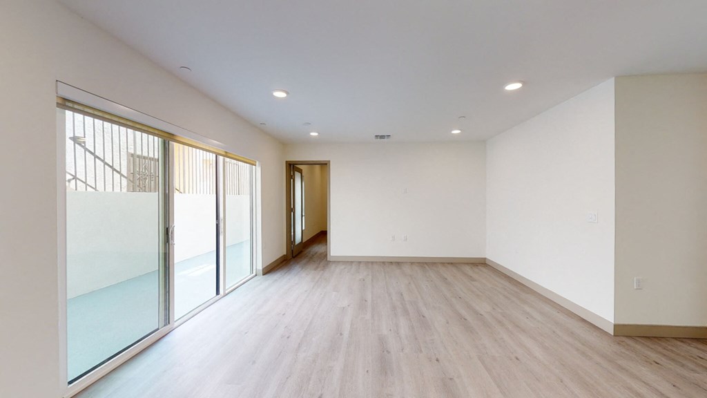 an empty living room with white walls and wood flooring