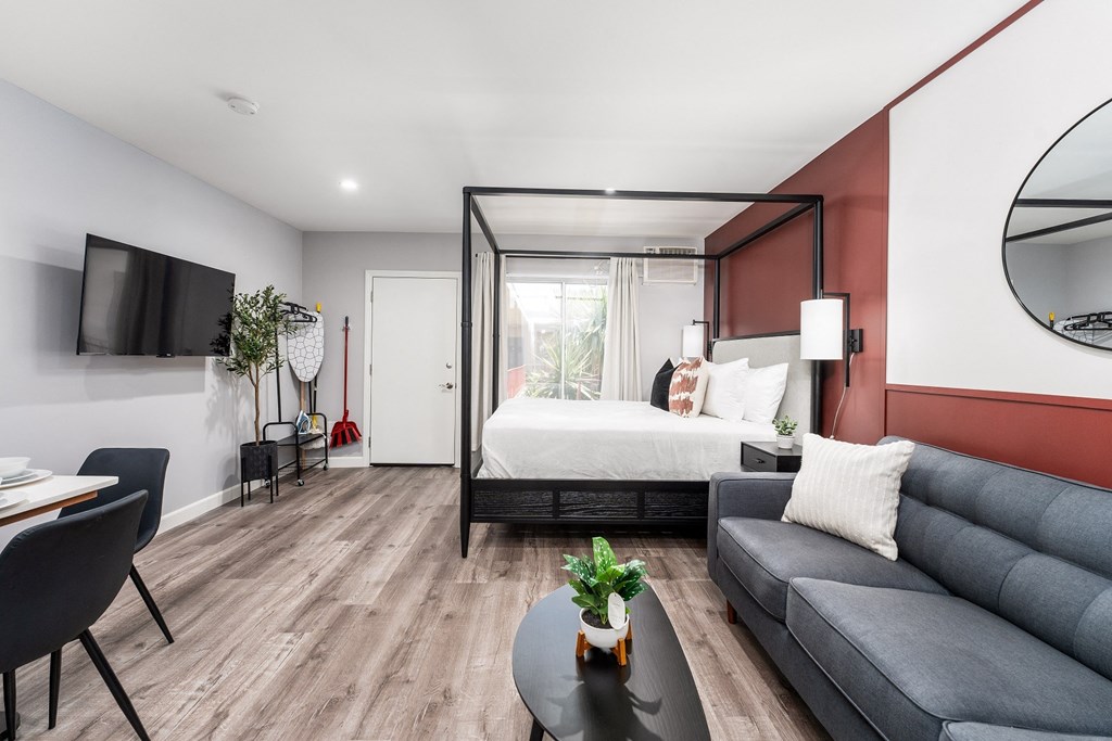 a bedroom with a bed and a couch and a table