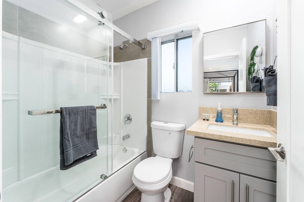 a white bathroom with a shower toilet and sink