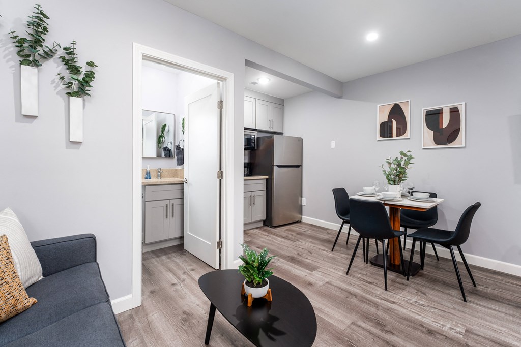 a living room and dining room with a table and chairs and a kitchen