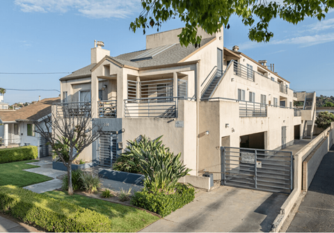 a white house with stairs and a street in front of it