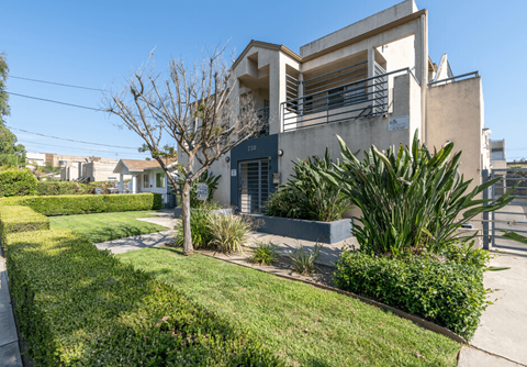 the front of a house with a yard and a sidewalk