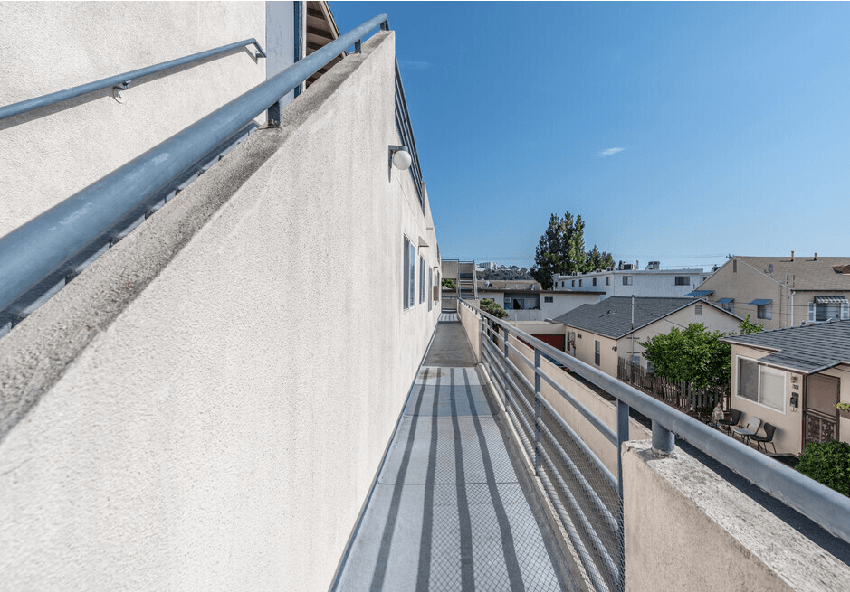 the side of a building with a balcony and a blue sky