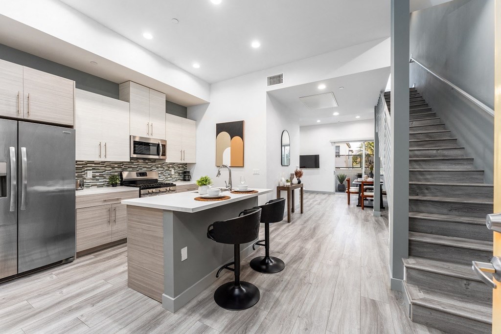 a kitchen with a counter top and a staircase at Lido Apartments - 4025 Grandview, California, 90066