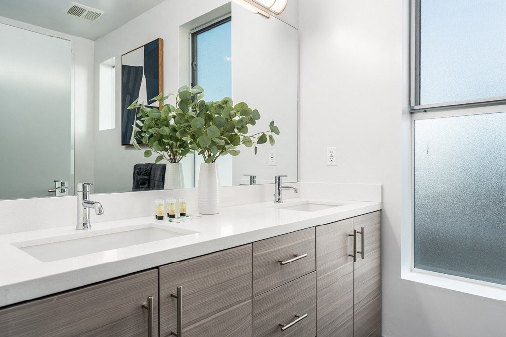 a bathroom with two sinks and a mirror at Lido Apartments - 4025 Grandview, California