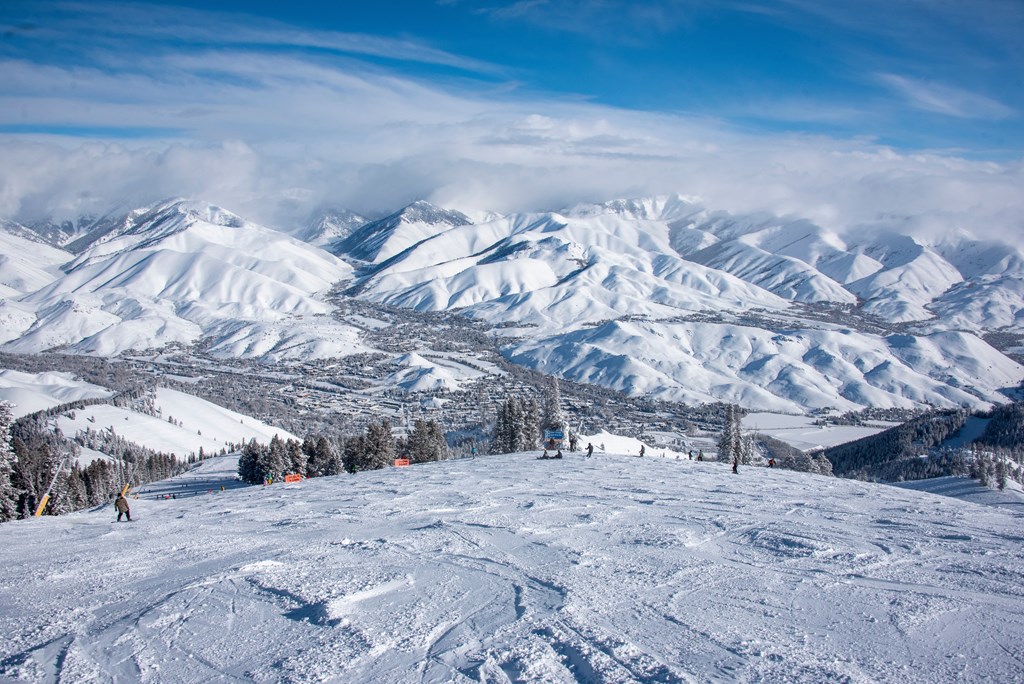 A snowy mountain landscape with skiers on the slopes.