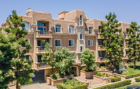 A large, multi-story residential building with a balcony on the second floor.