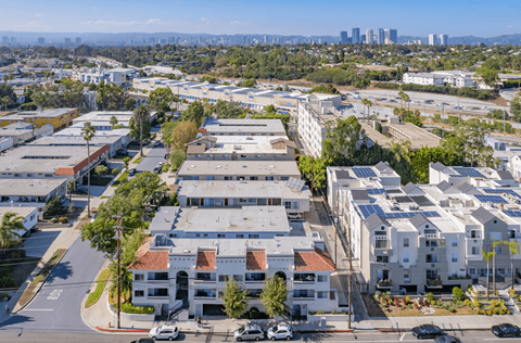 an aerial view of an apartment complex with a city in the background