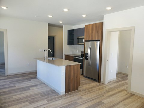 a kitchen with a large island and a stainless steel refrigerator