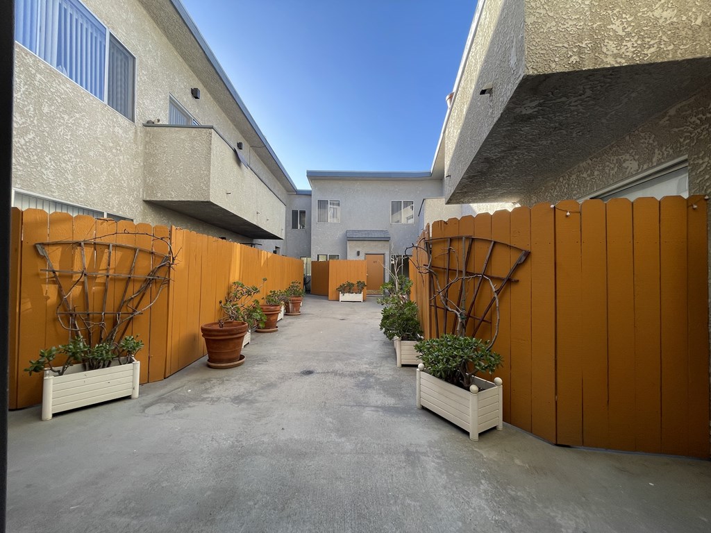 A courtyard with orange fences and potted plants.
