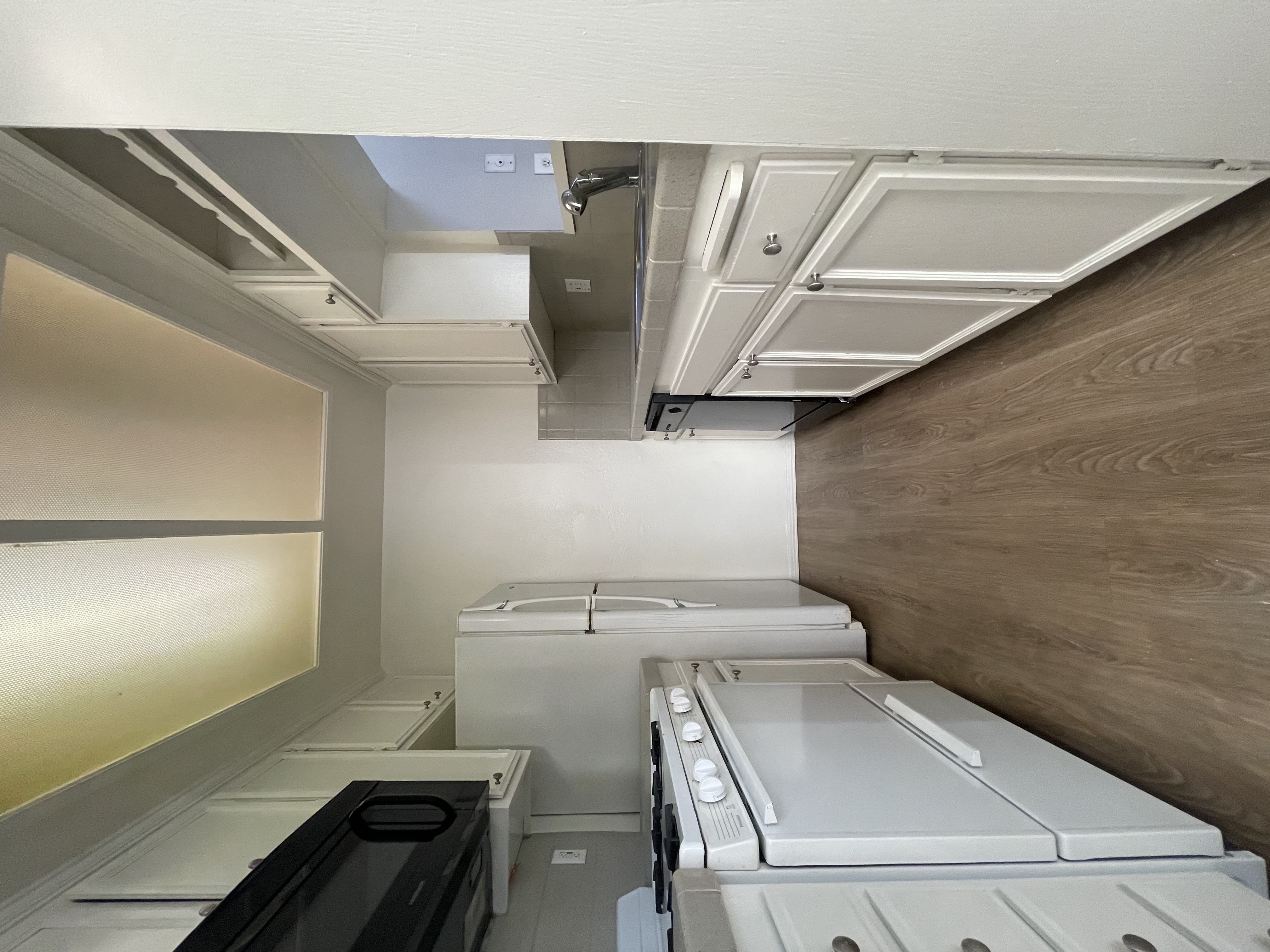 A row of white washing machines in a laundry room.