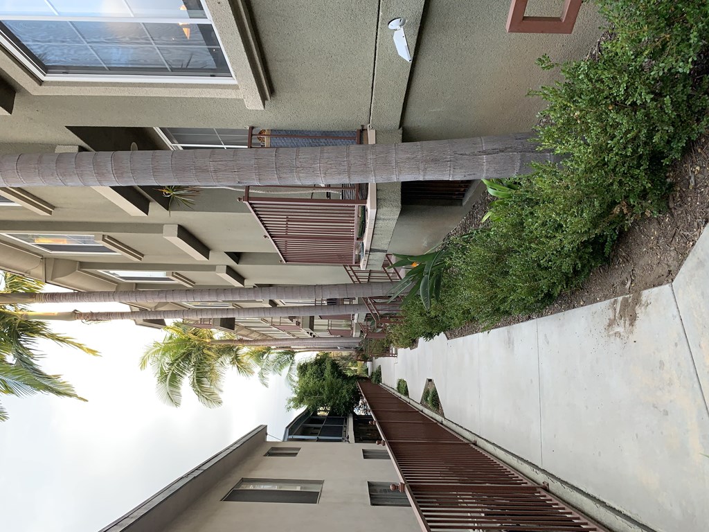A long staircase with a metal railing and plants on the side.