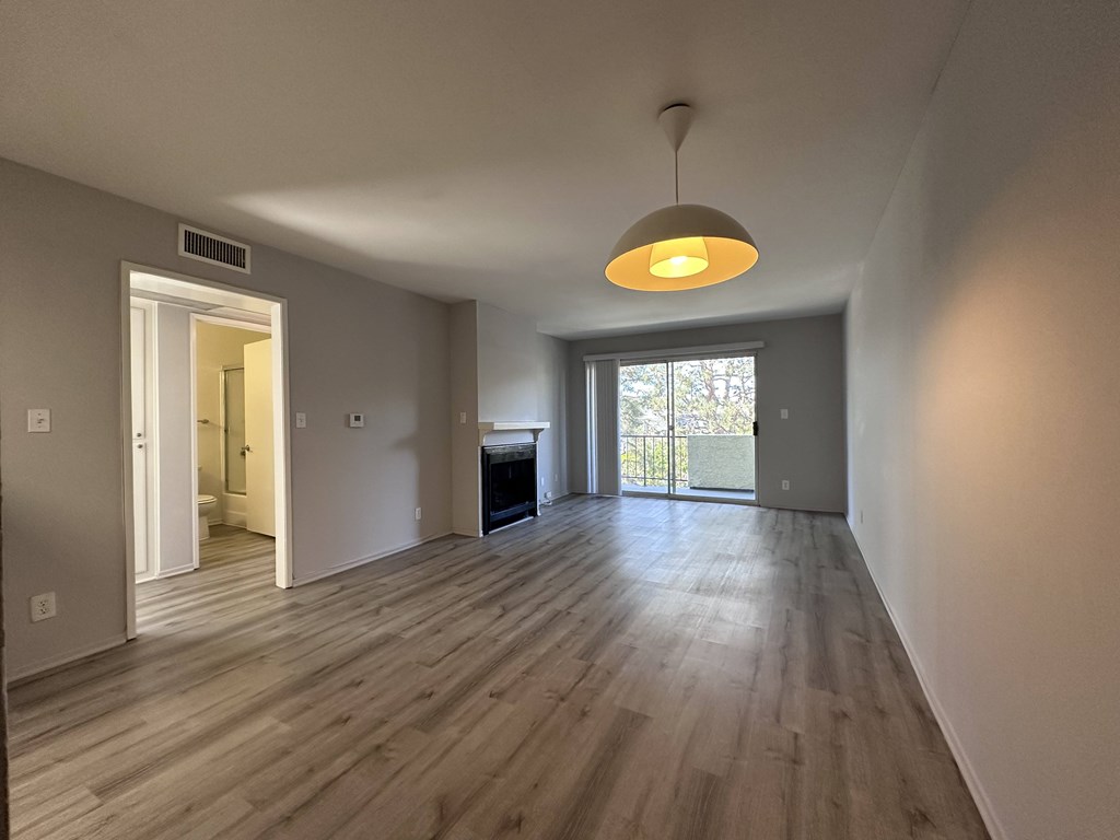 A room with wooden floors and a hanging light fixture.