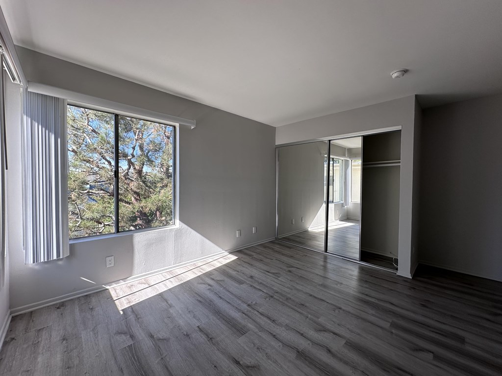 A room with a large window and sliding glass doors.