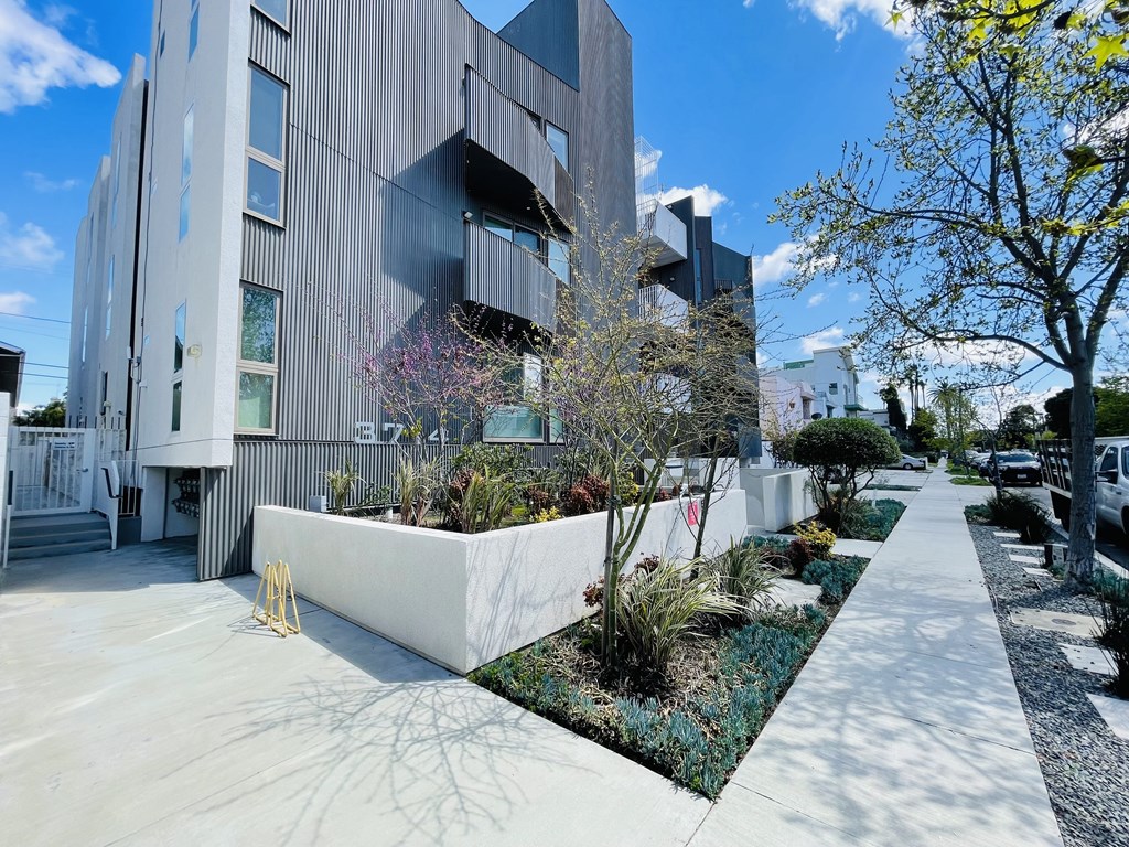 A modern building with a grey facade and a white planter box in front of it.