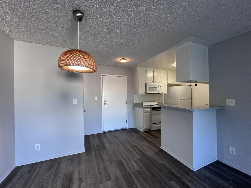 A kitchen area with a microwave, oven, and cabinets.