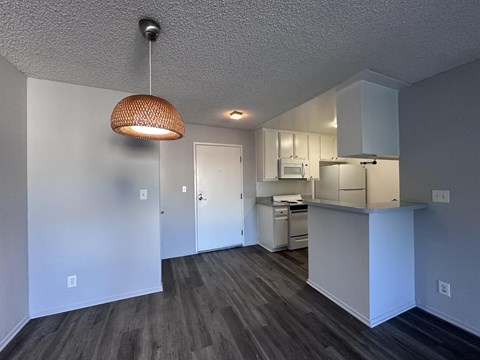 A kitchen area with a microwave, oven, and cabinets.