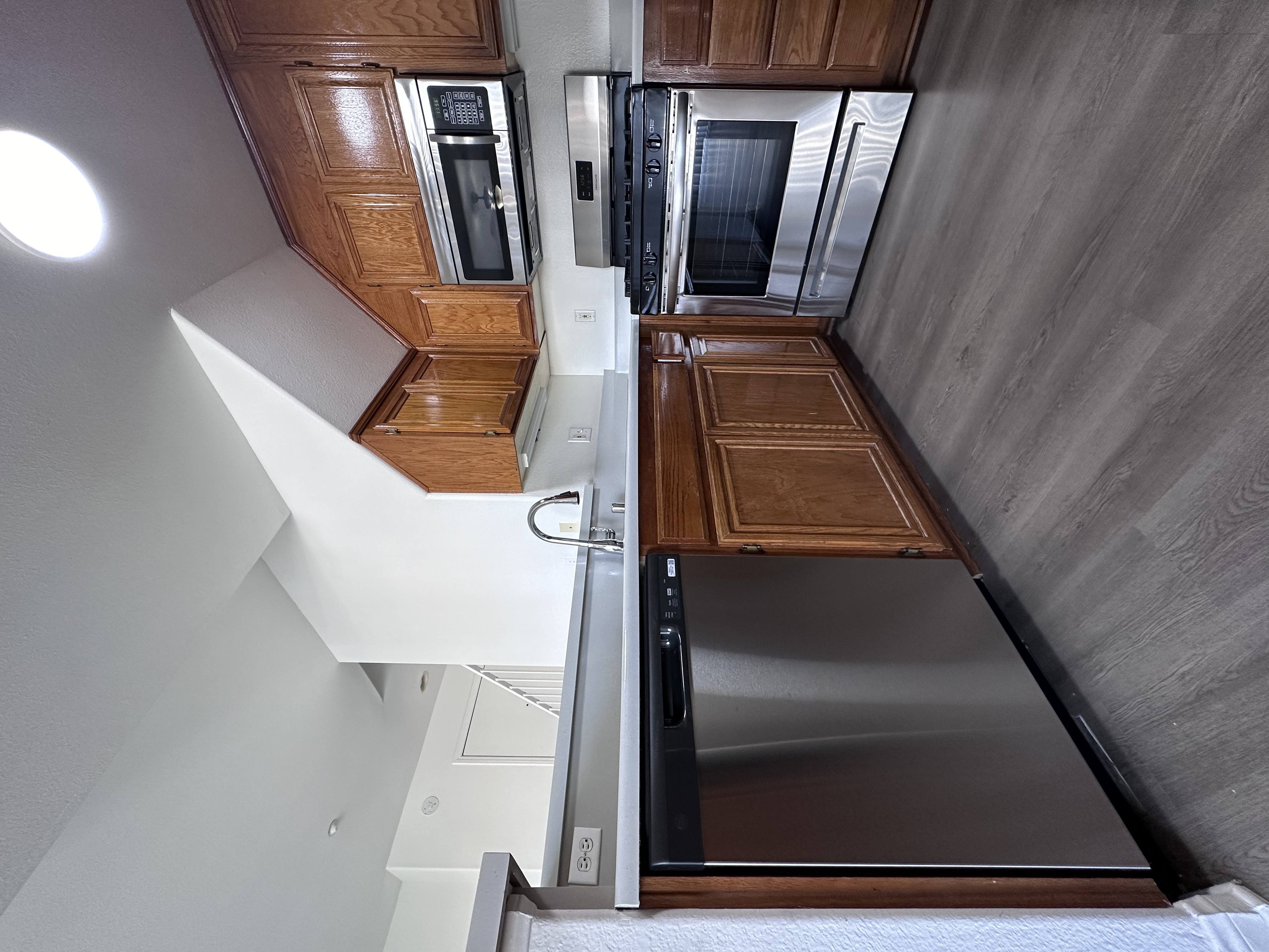 A modern kitchen with wooden cabinets and stainless steel appliances.