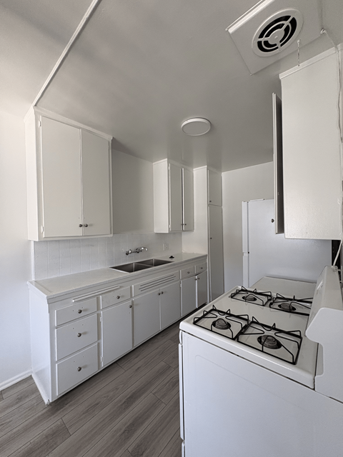 A white kitchen with a stove and cabinets.