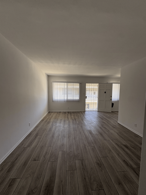 A room with wooden flooring and white walls.