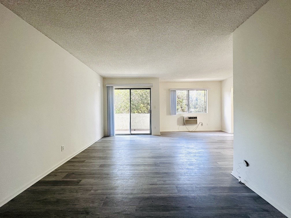 A room with a sliding glass door leading to a balcony.