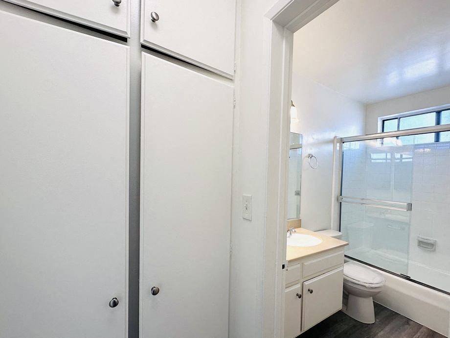 A white bathroom with a toilet, sink, and medicine cabinet.