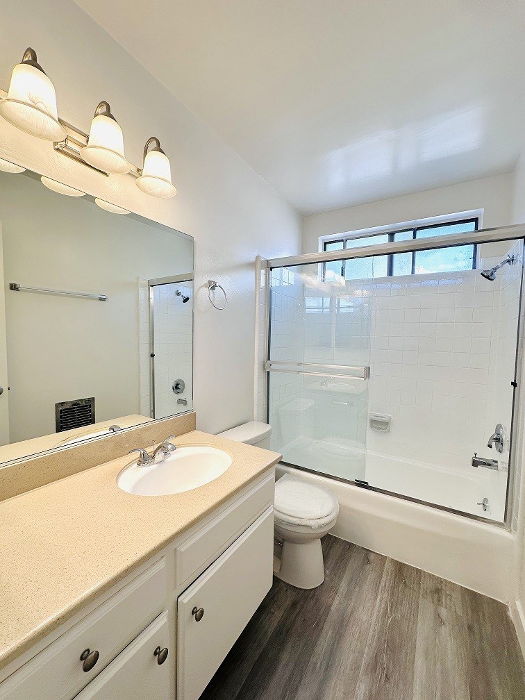 A bathroom with a sink, toilet, and shower.