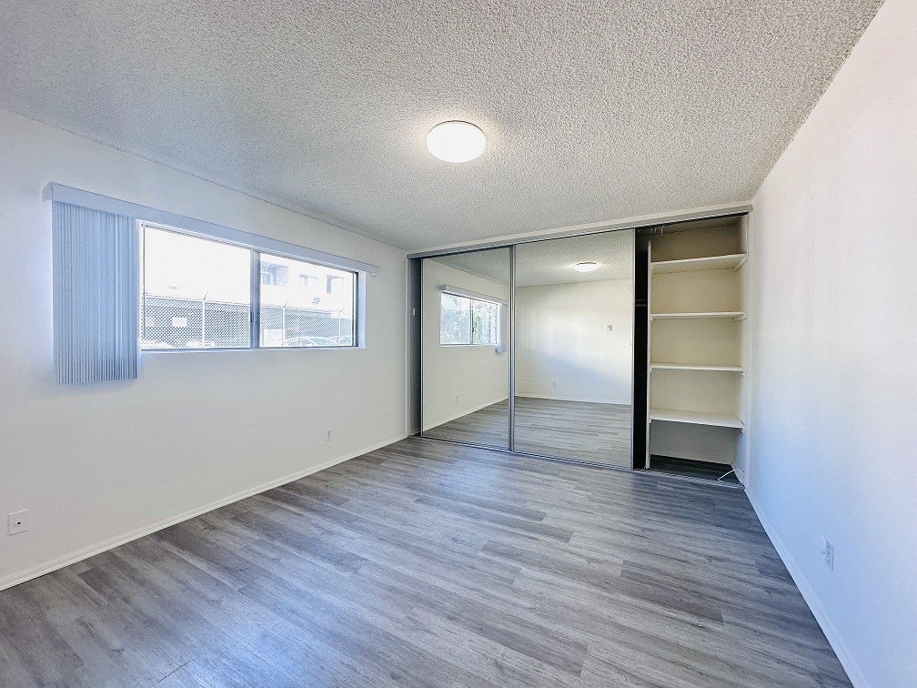 A room with a sliding door and a window with blinds.