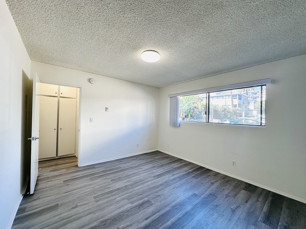 A room with a grey floor and a window letting in light.