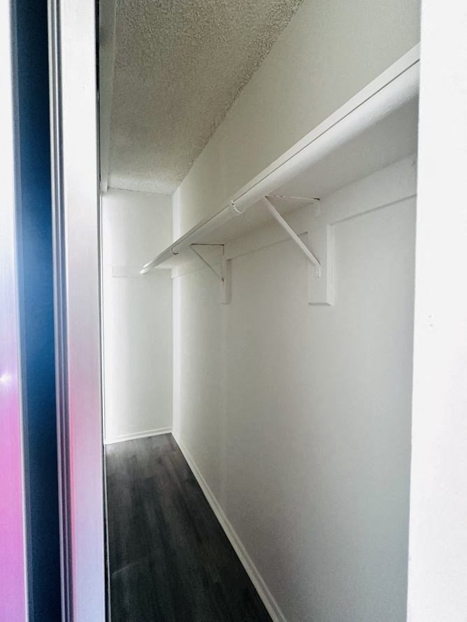 A long hallway with white walls and a black floor.