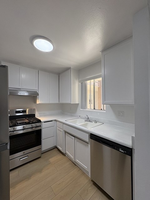 A kitchen with white cabinets and stainless steel appliances.