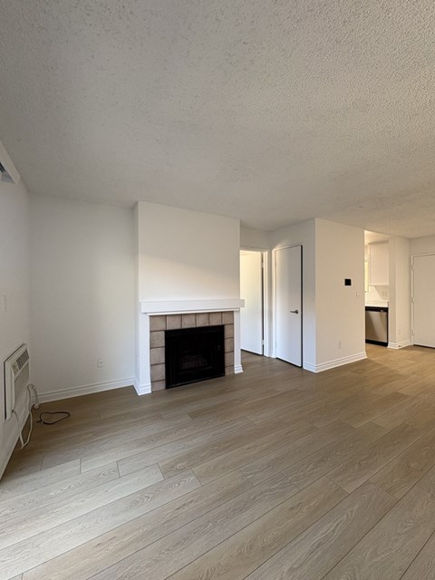A room with a fireplace and wooden floors.