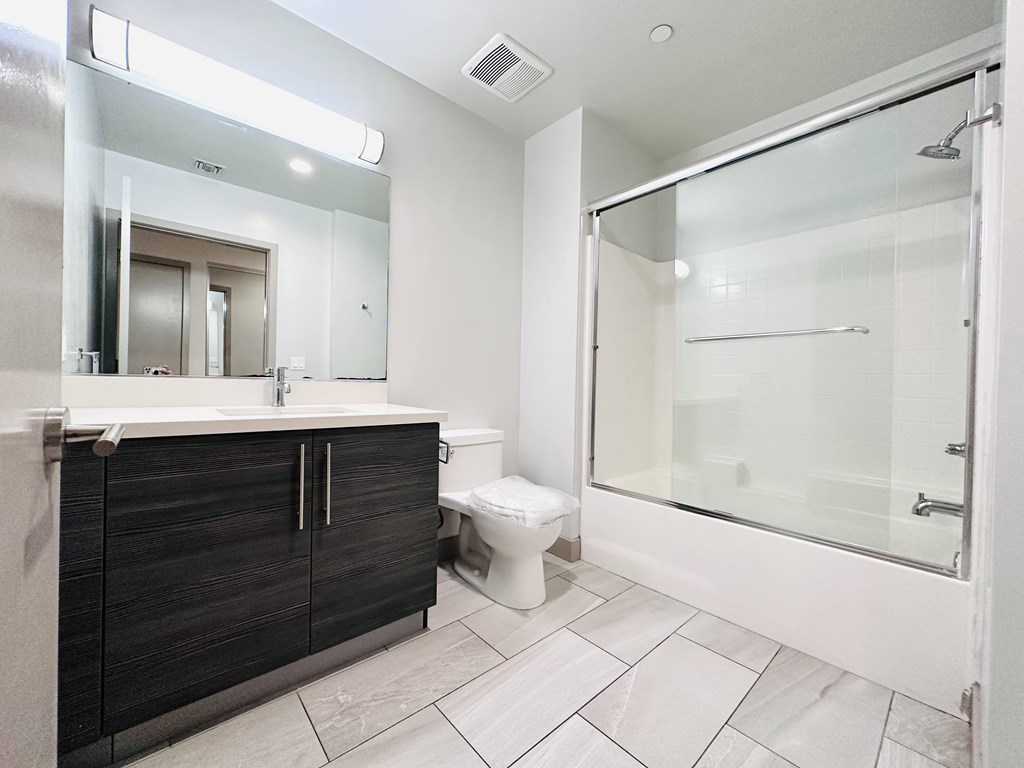 A bathroom with a toilet, sink, and shower.