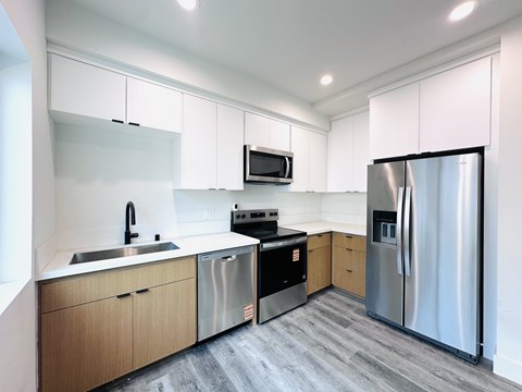 A modern kitchen with stainless steel appliances and wooden cabinets.