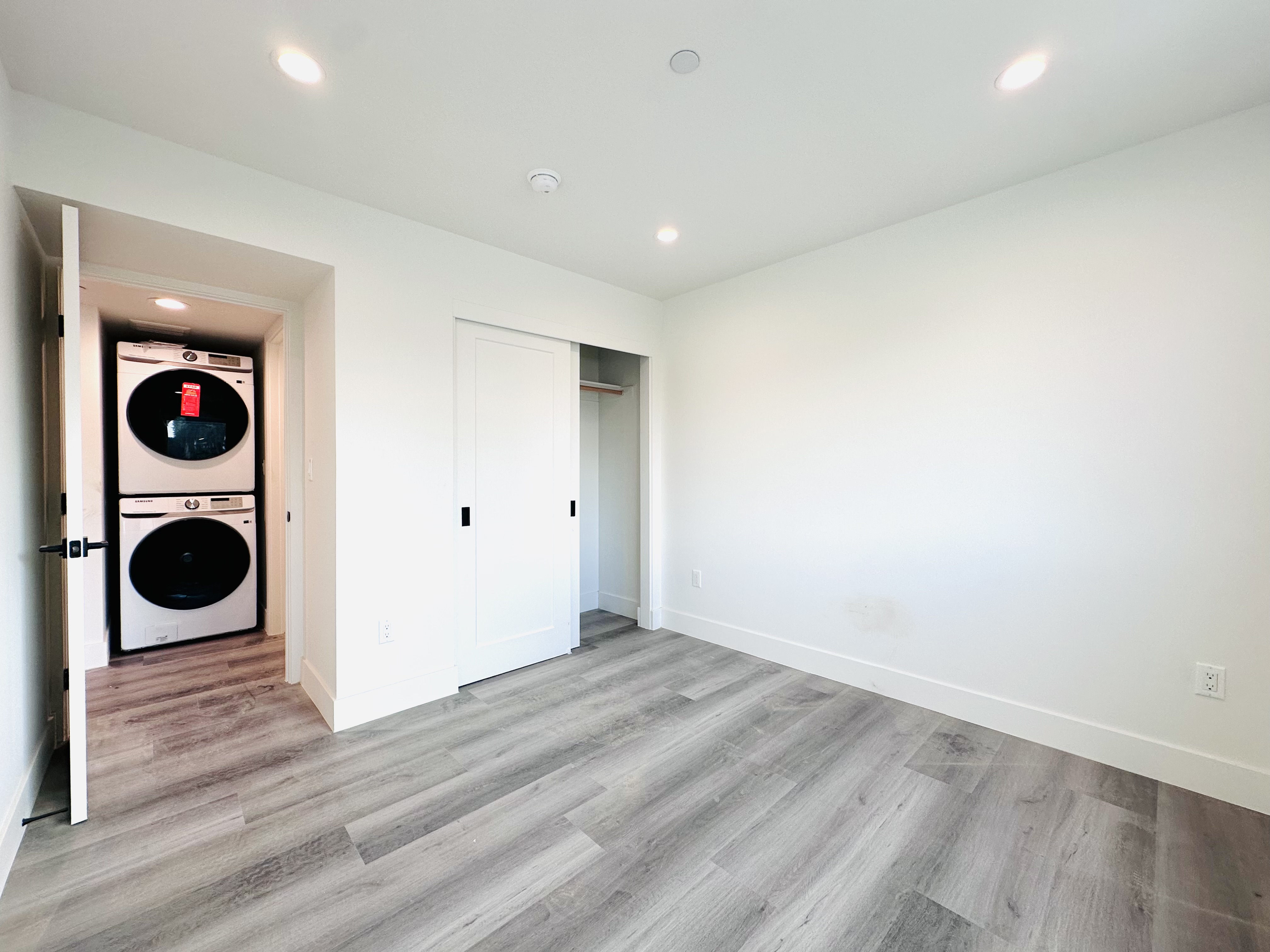 A modern room with a washer and dryer in the doorway.