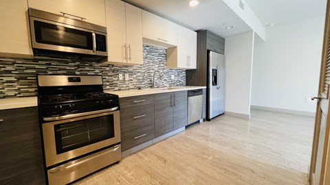 A modern kitchen with a stainless steel oven and microwave.