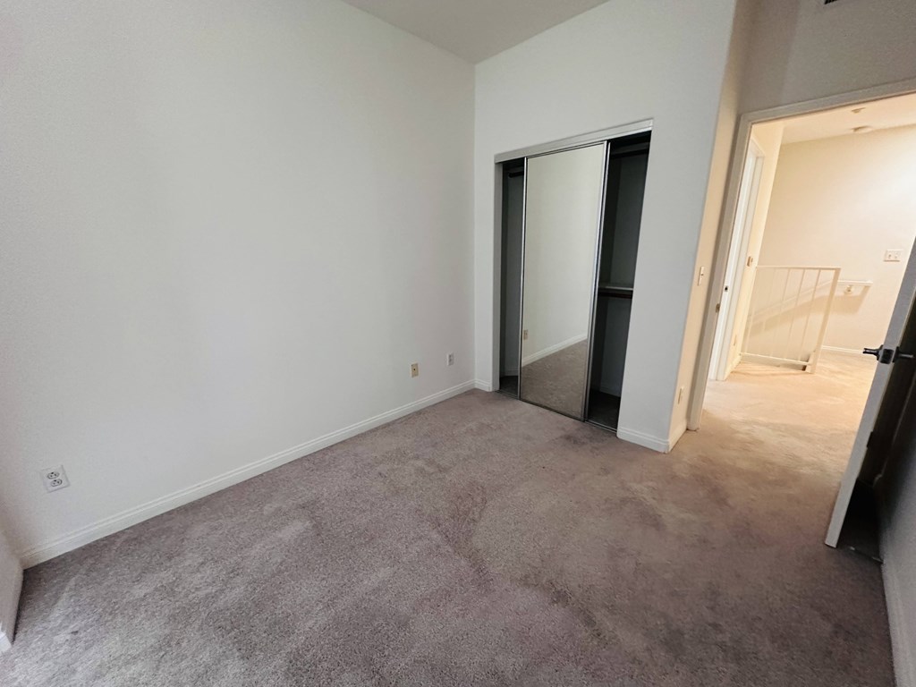 A room with a carpeted floor and a white wall.