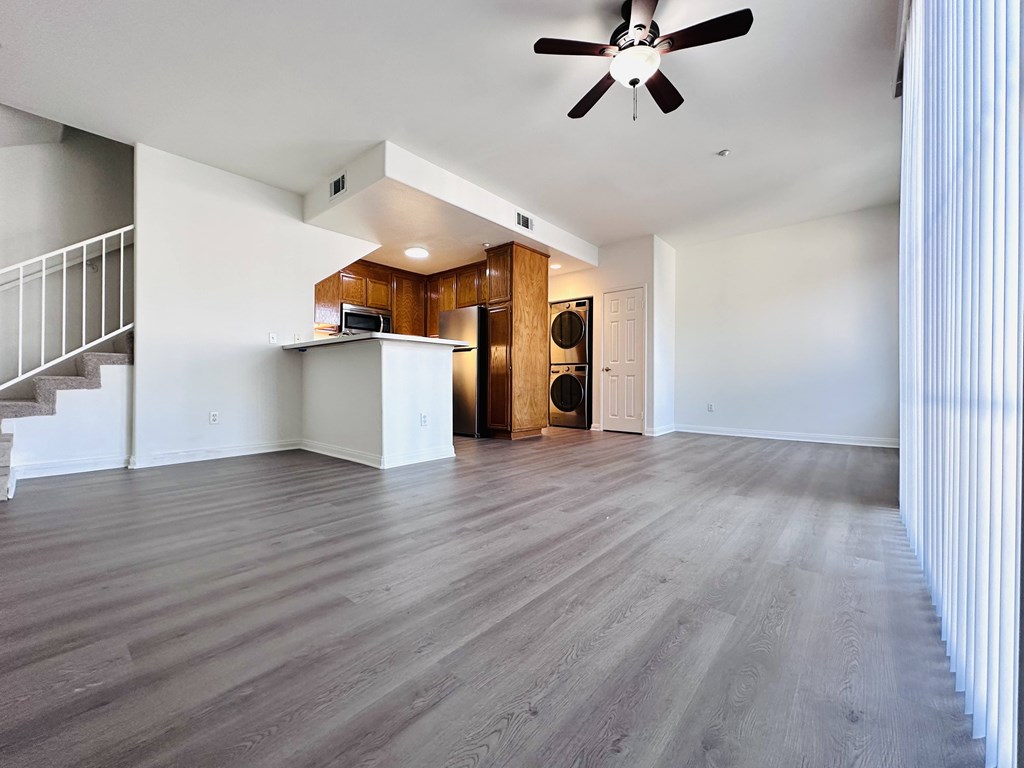 A spacious room with a ceiling fan and wooden flooring.