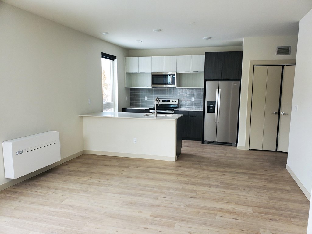 an empty kitchen with a refrigerator and a sink