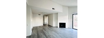 A spacious living room with a fireplace and a ceiling fan.at Lido Apartments - 101-197 N Ridgeway, Anaheim