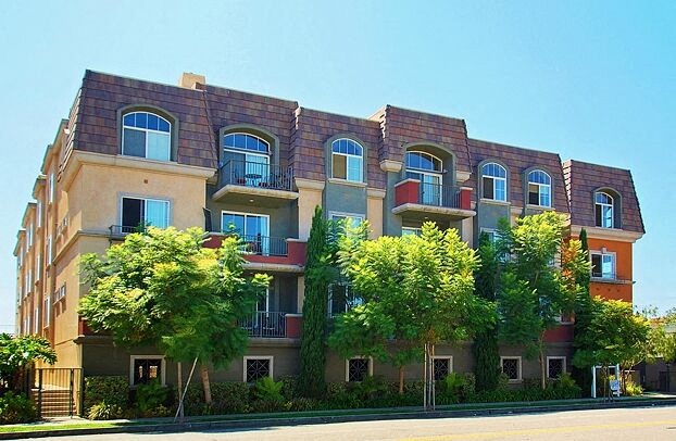 a large apartment building with trees in front of it