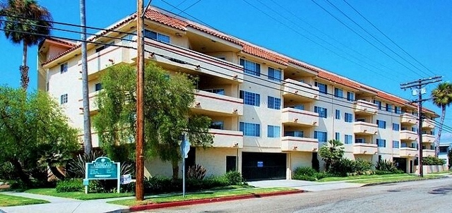 Four story apartment building with balconies and landscaping at Lido Apartments - 4280 Lindblade Dr, Los Angeles