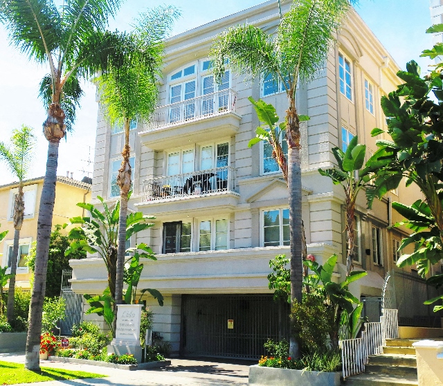 A building with a balcony and a sign in front of it.