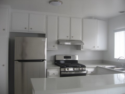 A kitchen with white cabinets and stainless steel appliances.