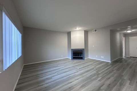 A spacious living room with a fireplace and hardwood flooring.