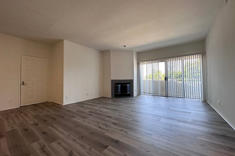 A spacious room with wooden flooring and a television in the corner. at Property Name Apartments, Los Angeles California