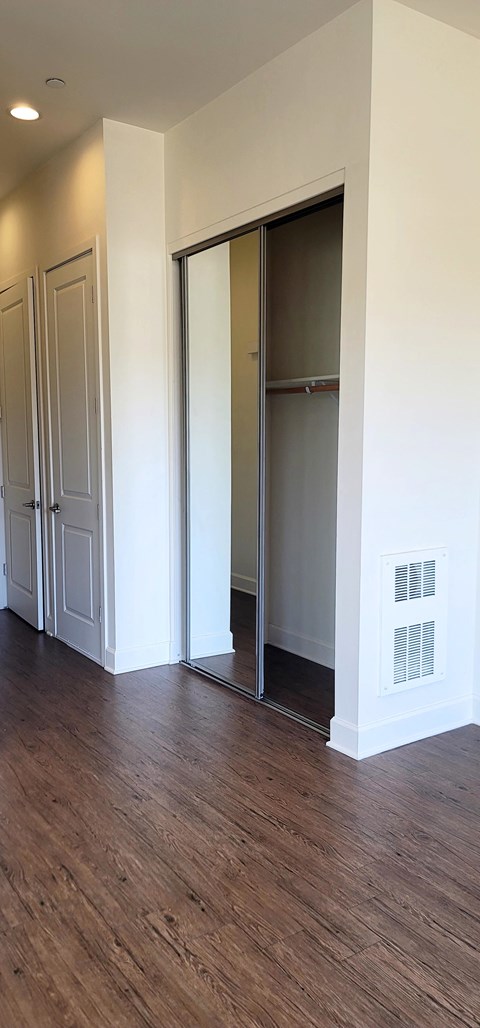 a living room with a hard wood floor and sliding glass doors